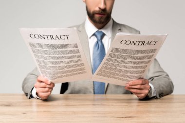 Gri masada tek başına otururken iş adamının sözleşmeleri okuması.