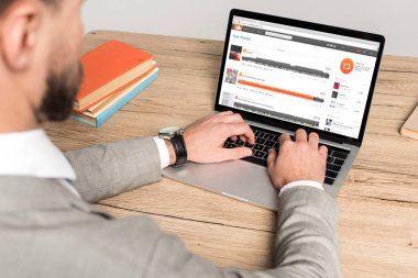 Kyiv, Ukrayna - 25 Kasım 2019: Gri ekranda Soundcloud web sitesi kullanan iş adamının kırpılmış görüntüsü