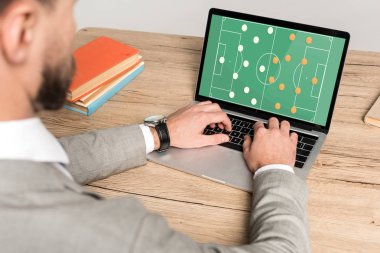 Gri dizüstü bilgisayarda futbol oyunu oynayan işadamlarının kırpılmış görüntüsü