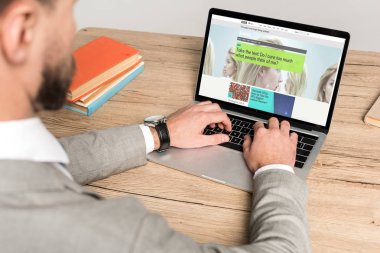 Kyiv, Ukrayna - 25 Kasım 2019: Gri ekranda Bbc Science web sitesi kullanan işadamının kırpılmış görüntüsü