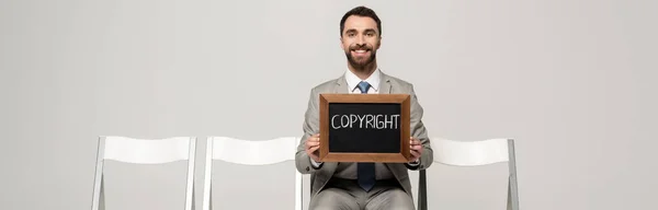 Panoramic Shot Happy Businessman Holding Chalkboard Word Copyright While Sitting — Stock Photo, Image