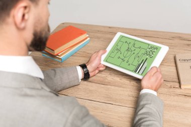 Gri ile izole edilmiş dijital tablette video oyunu oynayan işadamının kırpılmış görünümü
