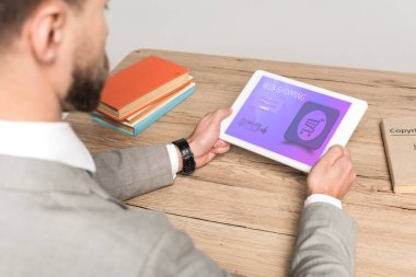Gri ekranda web alışveriş uygulaması ile dijital tablet kullanan işadamının kısmi görünümü