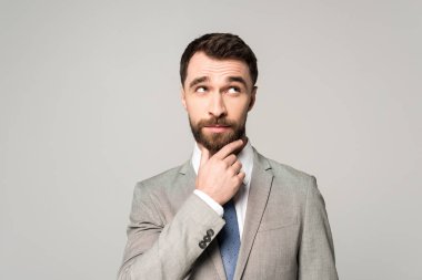 Yüze yakın el ele tutuşan düşünceli bir işadamı, gri yolda tek başına başka yere bakıyor.