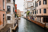 kanál a starobylé budovy s rostlinami v Benátkách, Itálie 