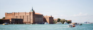 panoramic shot of floating vaporettos near ancient buildings in Venice, Italy  clipart