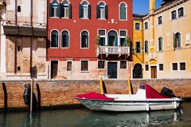 İtalya, Venedik 'te parlak ve renkli binaların yanında motorlu tekne 