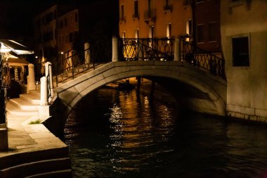 İtalya 'da Venedik' te gece yarısı eski binaların yakınındaki kanal üzerinde köprü 