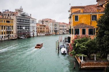 Kanalda yüzen vaporetto Venedik, İtalya 'daki antik binaları taşır 