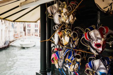 Venedik, İtalya 'da arka planda yüzen karnaval maskeleri ve motorlu tekne seçici odağı 