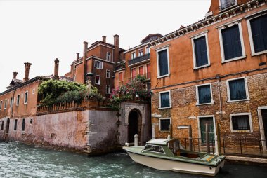 canal, motor boat and ancient buildings in Venice, Italy  clipart