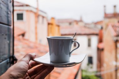 İtalya, Venedik 'te elinde bir fincan kahve tutan bir kadın manzarası 