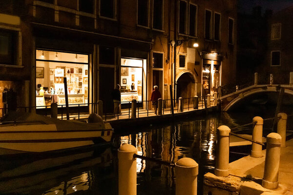 VENICE, ITALY - SEPTEMBER 24, 2019: motor boat near ancient building at night in Venice, Italy 