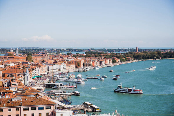 view of ancient buildings, motor boats and vaporettos floating on river in Venice, Italy 