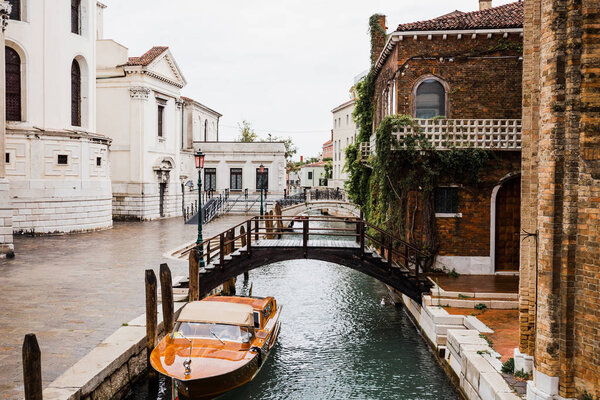 motor boat near bridge and ancient buildings in Venice, Italy 