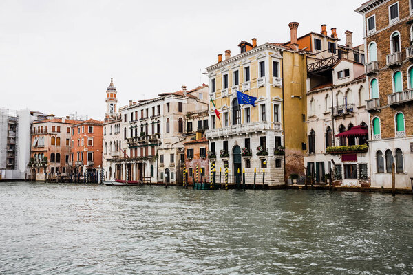 canal and ancient buildings with flags in Venice, Italy 