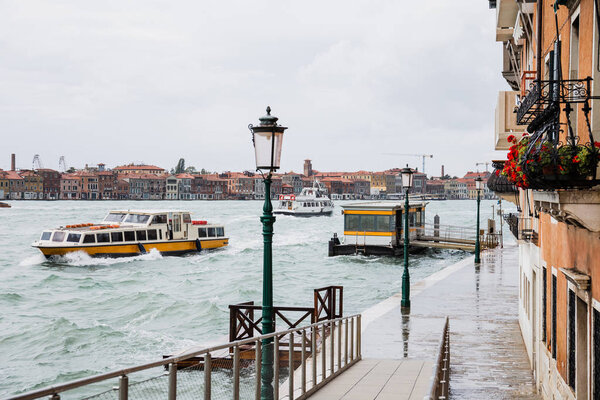 vaporettos floating on river near ancient buildings in Venice, Italy 