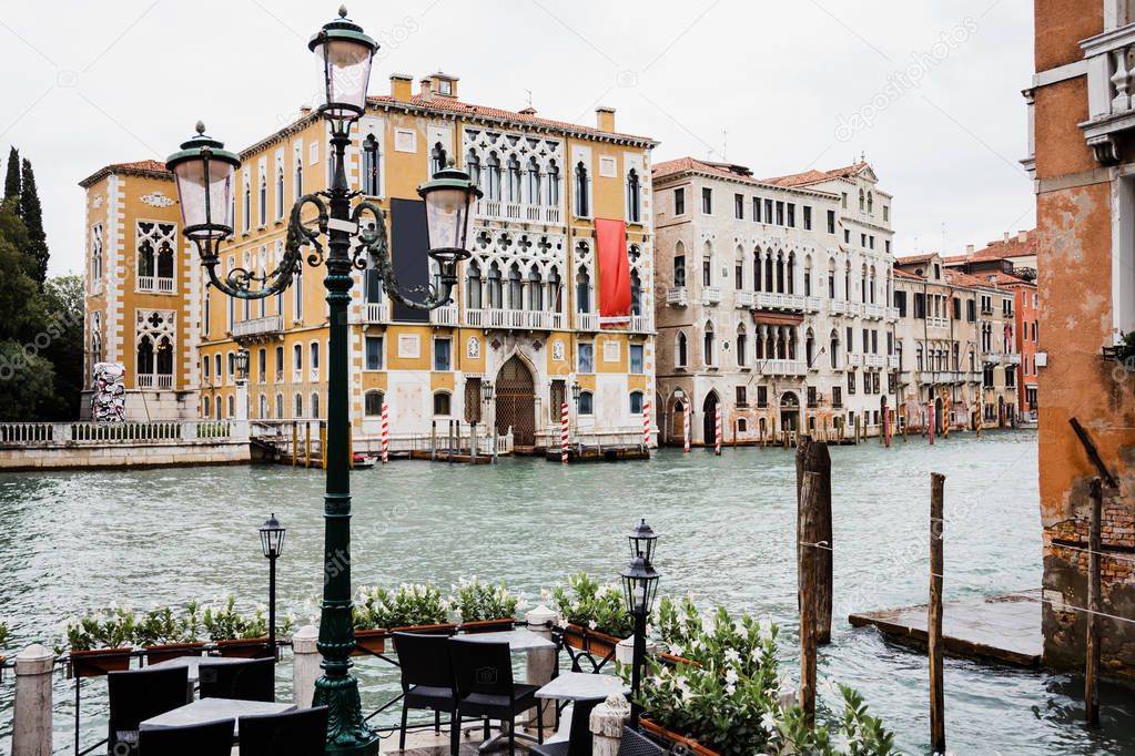 Outdoor cafe with view at canal and ancient buildings in Venice, Italy 