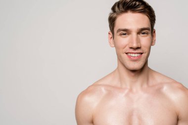 Güler yüzlü seksi adam, kaslı gövdesi griye bürünmüş.