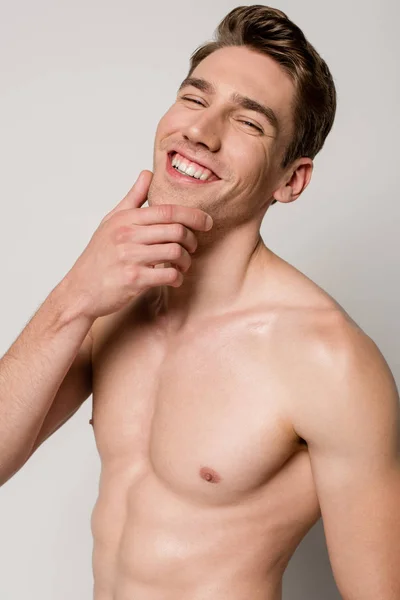 Sorrindo Homem Sexy Com Torso Muscular Tocando Queixo Isolado Cinza — Fotografia de Stock