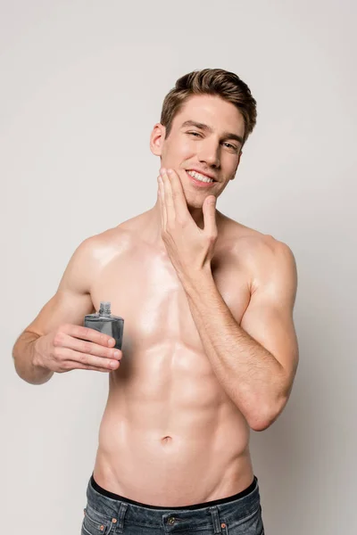 Sonriente Hombre Sexy Con Torso Muscular Aplicando Aftershave Cara Aislado — Foto de Stock