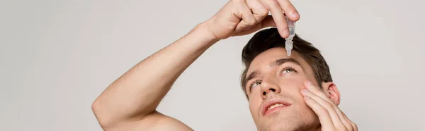 Сексуальный Мужчина Помощью Глазных Капель Изолированных Сером Панорамный Снимок — стоковое фото