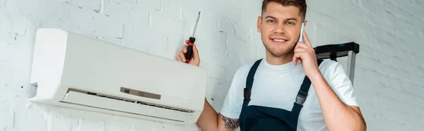 Panoramic Shot Happy Installer Holding Screwdriver While Talking Smartphone Air — Stock Photo, Image