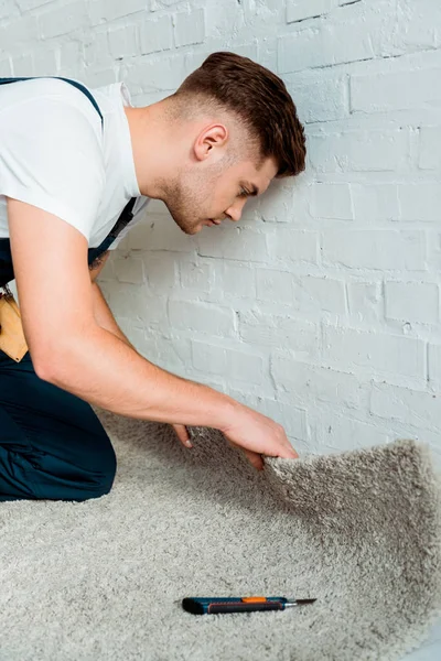 Side View Handsome Installer Holding Carpet Cutter Brick Wall — 스톡 사진