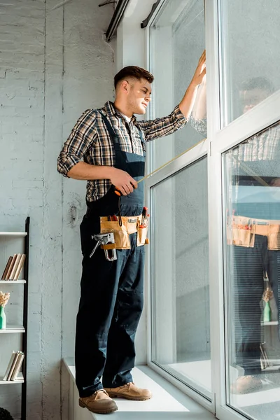 Installateur Steht Auf Fensterbank Fensternähe Und Hält Maßband — Stockfoto