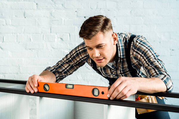  installer holding building level with measuring rack 