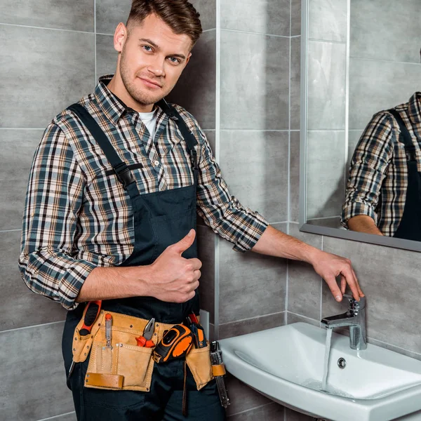 Schöner Installateur Steht Der Nähe Des Wasserhahns Mit Fließendem Wasser — Stockfoto