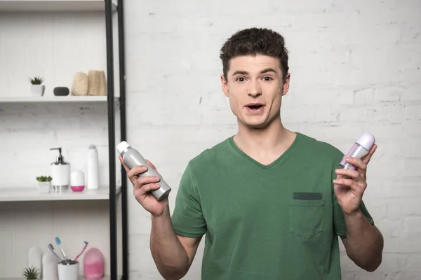 Excited Young Man Green Shirt Looking Camera While Holding Deodorants — Stock Photo, Image