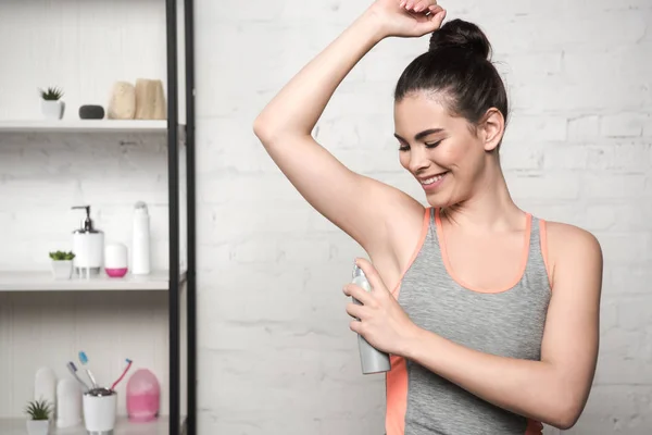 Donna Sorridente Camicia Grigia Senza Maniche Spruzzando Deodorante Ascelle — Foto Stock