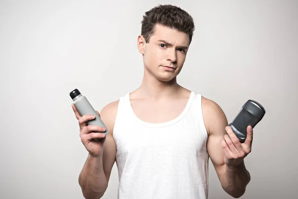 Skeptical Man White Sleeveless Shirt Holding Deodorants Isolated Grey — Stock Photo, Image