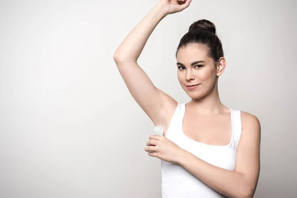 Positive Woman Looking Camera While Applying Deodorant Underarm Isolated Grey — 스톡 사진