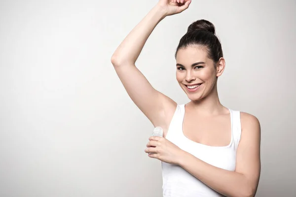 Mujer Alegre Sonriendo Cámara Mientras Aplica Desodorante Axila Aislada Gris — Foto de Stock