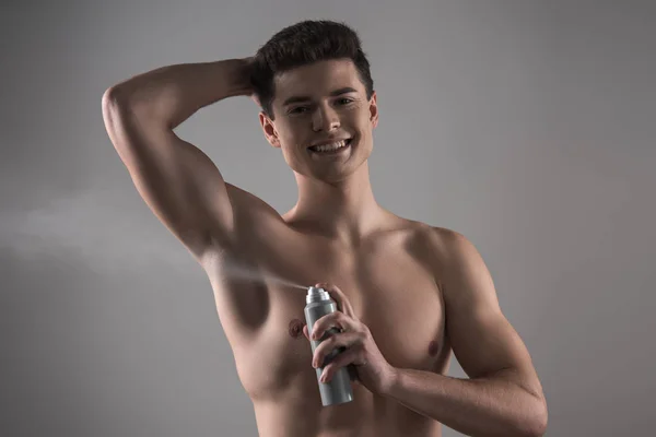 Glad Skjorta Man Tittar Kameran När Sprutar Deodorant Underarmen Isolerad — Stockfoto