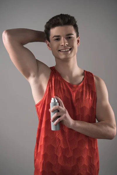 Smiling Man Red Sleeveless Shirt Holding Deodorant Underarm Isolated Grey — Stock Photo, Image