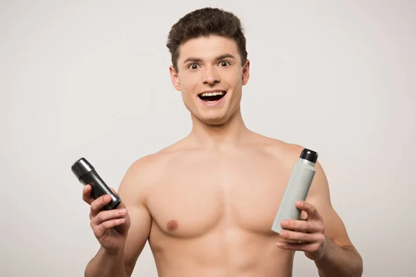 Homem Sem Camisa Animado Olhando Para Câmera Enquanto Segurando Desodorizantes — Fotografia de Stock