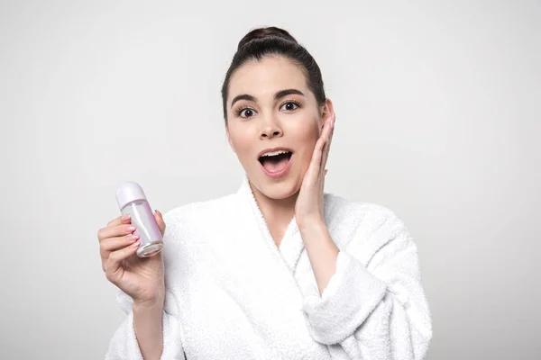 Podekscytowana Kobieta Szlafroku Trzyma Dezodorant Patrząc Kamerę Odizolowaną Szaro — Zdjęcie stockowe