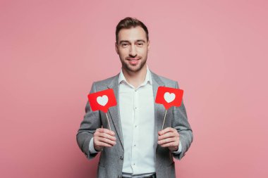 Sevgililer günü için kalpleri olan mutlu, duygusal bir adam pembe kartlarla izole edilmiş. 