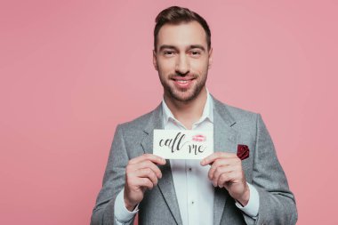 bearded man holding valentines day card with call me sign, isolated on pink clipart