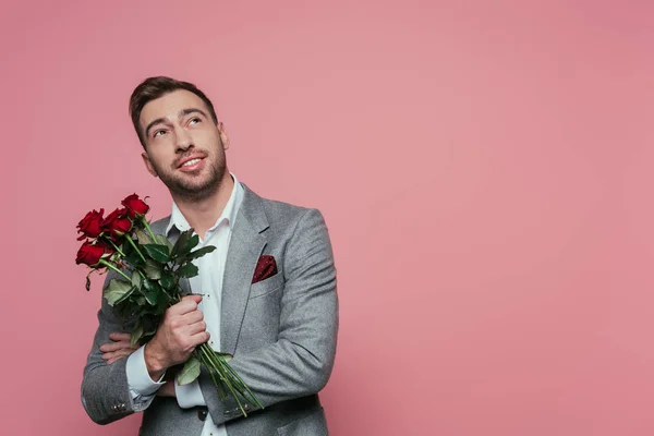 Smiling Pensive Man Suit Holding Bouquet Red Roses Isolated Pink — Stock Photo, Image