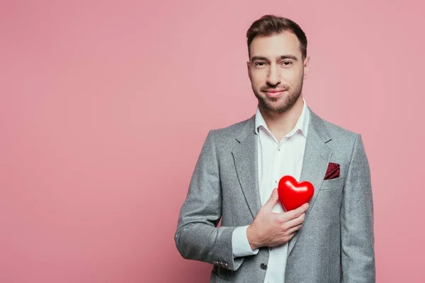 Pohledný Muž Držící Červené Srdce Valentýna Izolovaný Růžové — Stock fotografie