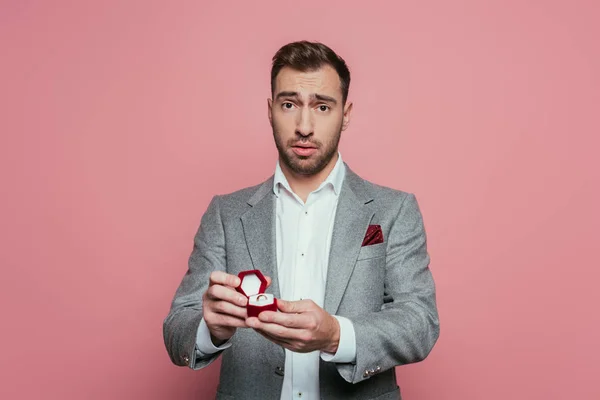 Confused Man Holding Box Proposal Ring Isolated Pink — Stockfoto