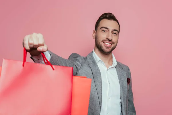 Homem Alegre Segurando Sacos Compras Isolado Rosa — Fotografia de Stock