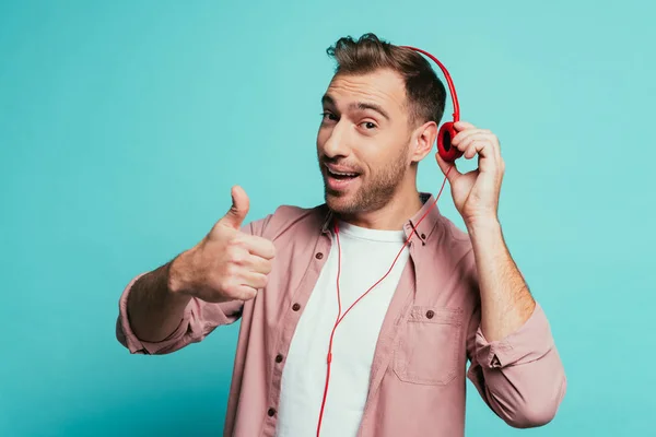 Happy Man Listening Music Headphones Showing Thumb Isolated Blue — 스톡 사진
