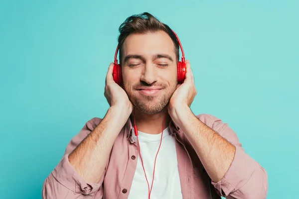 Hombre Positivo Escuchando Música Con Auriculares Aislado Azul —  Fotos de Stock