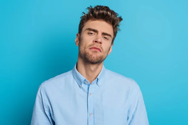 Joven Hombre Escéptico Mirando Cámara Fondo Azul — Foto de Stock