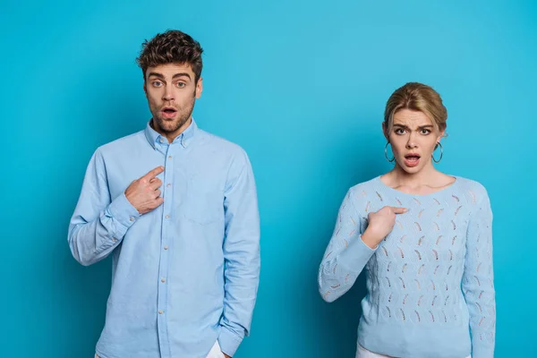 Shocked Man Woman Pointing Fingers Themselves While Looking Camera Blue — Stock Photo, Image